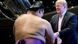 President Donald Trump presents the President's Cup to sumo wrestler Asanoyama in Tokyo on May 26, 2019
