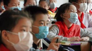 Grupo de niños con mascarilla en clase