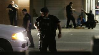 Dallas police detain a driver after sniper shootings