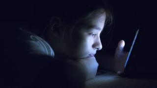 Niña mirando pantalla del celular