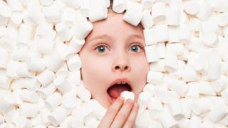 Niña comiéndose un marshmellow