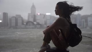 香港尖沙咀海傍一名女士冒着台风观赏维多利亚港(23/8/2017)
