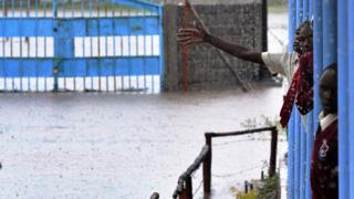 Kenyan school children gather on a verandah outside their classroom at Isinya Secondary School at Isinya some 58kms south-east of Nairobi on March 15, 2018, after classes were stopped due to flash floods in the school compound. Unusually heavy showers have heralded the beginning of Kenya"s long rainy season with flooding widely expected with transportation along the county"s main road to the Kenya-Tanzania border interrupted for hours.