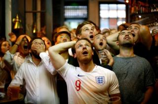 England fans react as they watch the match in London