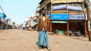 Kishan Lal stands in an empty street the northern Indian city of Allahabad,