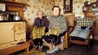 Two women knitting Fair Isle style jumpers pose in the living room of a cottage on one of the Shetland Islands in 1970.