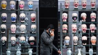 A man walks past a show window displaying various face coverings in Glasgow, Scotland on 2 September 2020.