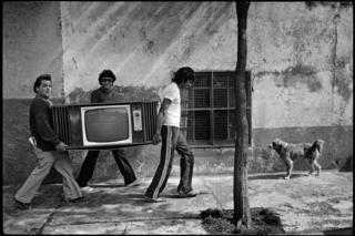 Men carrying a television in the street