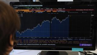 A trader looks at his screen as prices rise