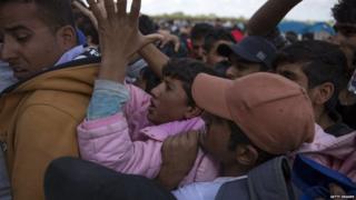 Migrants try to get on a bus after crossing into Hungary from Serbia. Photo: 8 September 2015