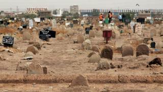 A picture taken on June 13, 2020, shows members of a forensic team at a cemetary, where a mass grave of conscripts killed in 1998 was discovered, in the Sahafa neighbourhood.