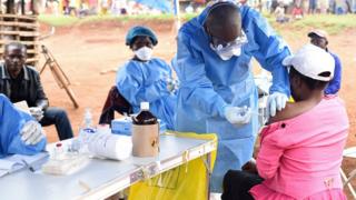 Конголезский медработник вводит вакцину против лихорадки Эбола женщине, которая контактировала с больным лихорадкой Эбола в деревне Манджина в Северном Киву