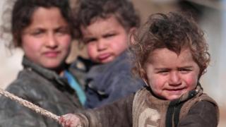 Internally displaced Syrian children who fled Raqqa city stand near their tent in Ras al-Ain province, Syria