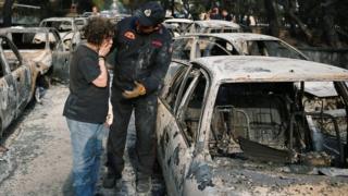 A woman reacts as she tries to find her dog, following a wildfire at the village of Mati, near Athens, Greece July 24, 2018