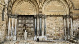 Der christliche Pilger steht vor verschlossenen Türen der Grabeskirche in Jerusalem