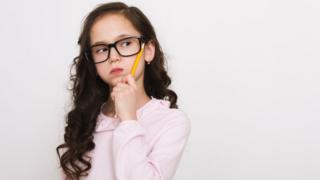 Niña piensa con un lápiz.