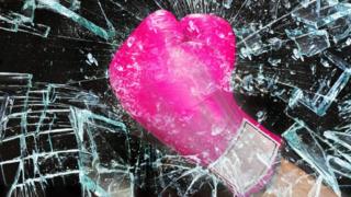 A boxing glove smashes through glass