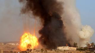 An explosion and smoke rise after an airstrike by the Saudi-led coalition at a weapons depot in Sanaa, Yemen, Friday, Sept. 11, 2015. Saudi Arabia is leading a coalition of mainly Gulf nations fighting the Houthis, who seized the capital, Sanaa, last September. (AP Photo/Hani Mohammed)