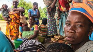 Women carrying their children with their scarce belongings after the passage of the cyclone Idai in Matarara