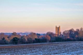 Sunset over a field and church