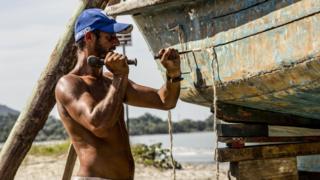 Wladimir, pescador de Ubatuba, calafetando seu barco