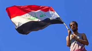 عراقي يحمل علم بلاده