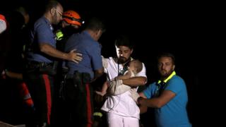 A doctor carries a child after an earthquake hits the island of Ischia, off the coast of Naples