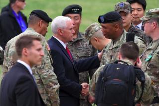 南北軍事境界線近くで米韓の軍関係者と会うペンス米副大統領(写真中央、17日)