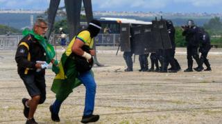 Security forces confront supporters of Brazilian former President Jair Bolsonaro as they invade Planalto Presidential Palace in Brasilia on January 8, 2023