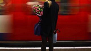 Una mujer espera al tren tras el trabajo.