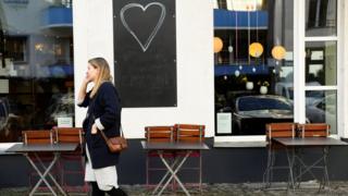 Piled chairs and tables are seen in front of a chocolate store in Berlin