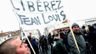 Two men hold a banner that reads, "free Jean Louis" as they rally in support of a farmer being prosecuted for the attempted murder of an alleged fuel thief, during a demonstration outside the court of appeal in Reims, northeastern France, on 13 February, 2020.