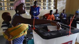 Une femme portant un enfant vote le 10 octobre dernier à Monrovia.