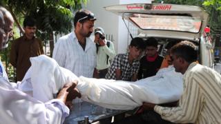 পাকিস্তানে মদ পানে মৃত একজনকে গাড়িতে উঠানো হচ্ছে