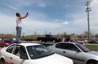 Un hombre se sube en su coche buscando señal para el celular.