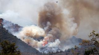 A firefighting aircraft drops water on the Apple Fire in Banning, California