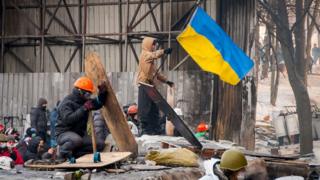 Протестувальники зі щитами і прапорами на барикадах
