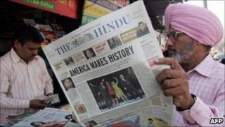 Indian Sikh man browses newspaper in shop