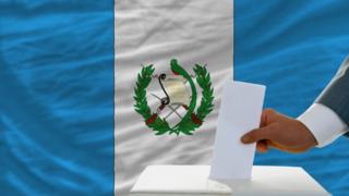 Urna con bandera de Guatemala y hombre votando
