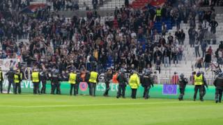Police forces and stewards prevent Olympique Lyonnais fans from invading the pitch after the UEFA Europa League Quarter Final Leg Two match between Olympique Lyonnais and West Ham United at OL Stadium on April 14, 2022 in Lyon, France
