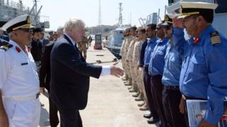 Борис Джонсон приветствует членов ливийской береговой охраны.