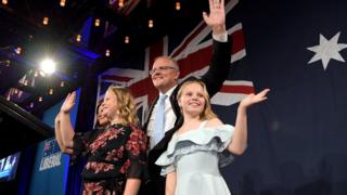 Scott Morrison and his children wave to supporters at his victory party