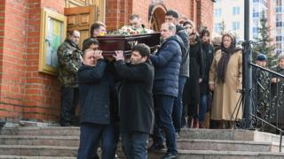 Men carry the coffin of a victim of a shopping mall fire out of a church during a funeral service in the industrial city of Kemerovo in western Siberia on March 28, 2018. Russia on March 28, 2018