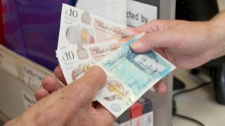 Man withdrawing cash at a post office