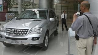 Man looking through window at new car