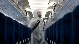 A health worker sprays disinfectant inside a Vietnam Airlines airplane in Hanoi, Vietnam