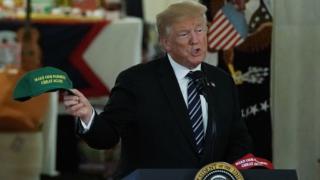 Trump con una gorra que dice "Haz que nuestros granjeros vuelvan a ser grandes"