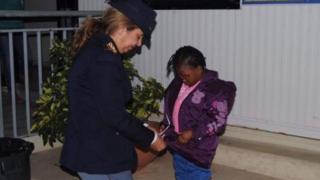 Un agent de la police italienne prenant soin de l'Oumoh, qui pourrait retrouvait sa mère avant la fin de l'année.