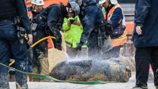 Police from the explosive ordinance disposal unit hose down a defused US-made bomb