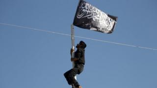 Nusra üyesi bayrağa uzanıyor